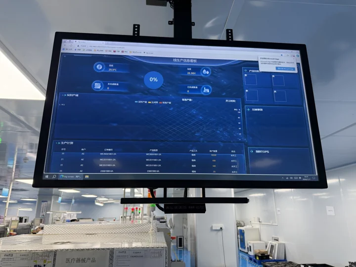 Blue dashboard on a monitor above the factory floor — Shenzhen PCBA factory